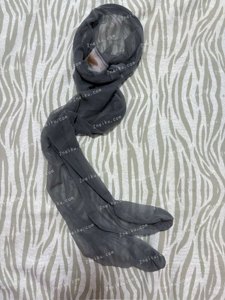 一条带有月经痕迹的无内灰色连裤袜（原味灰丝）摊放在床单上的照片 - 缩略图