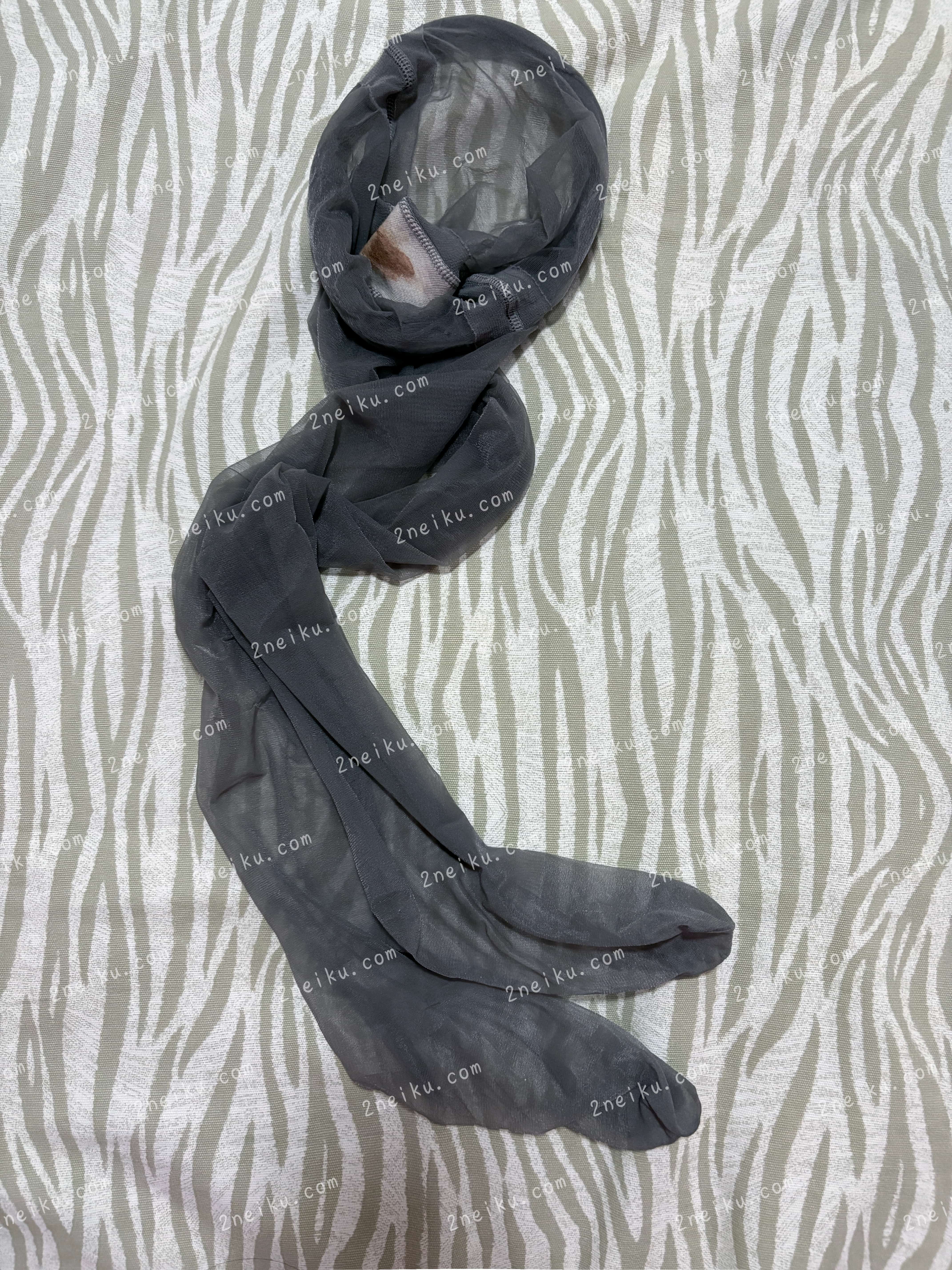 一条带有月经痕迹的无内灰色连裤袜（原味灰丝）摊放在床单上的照片