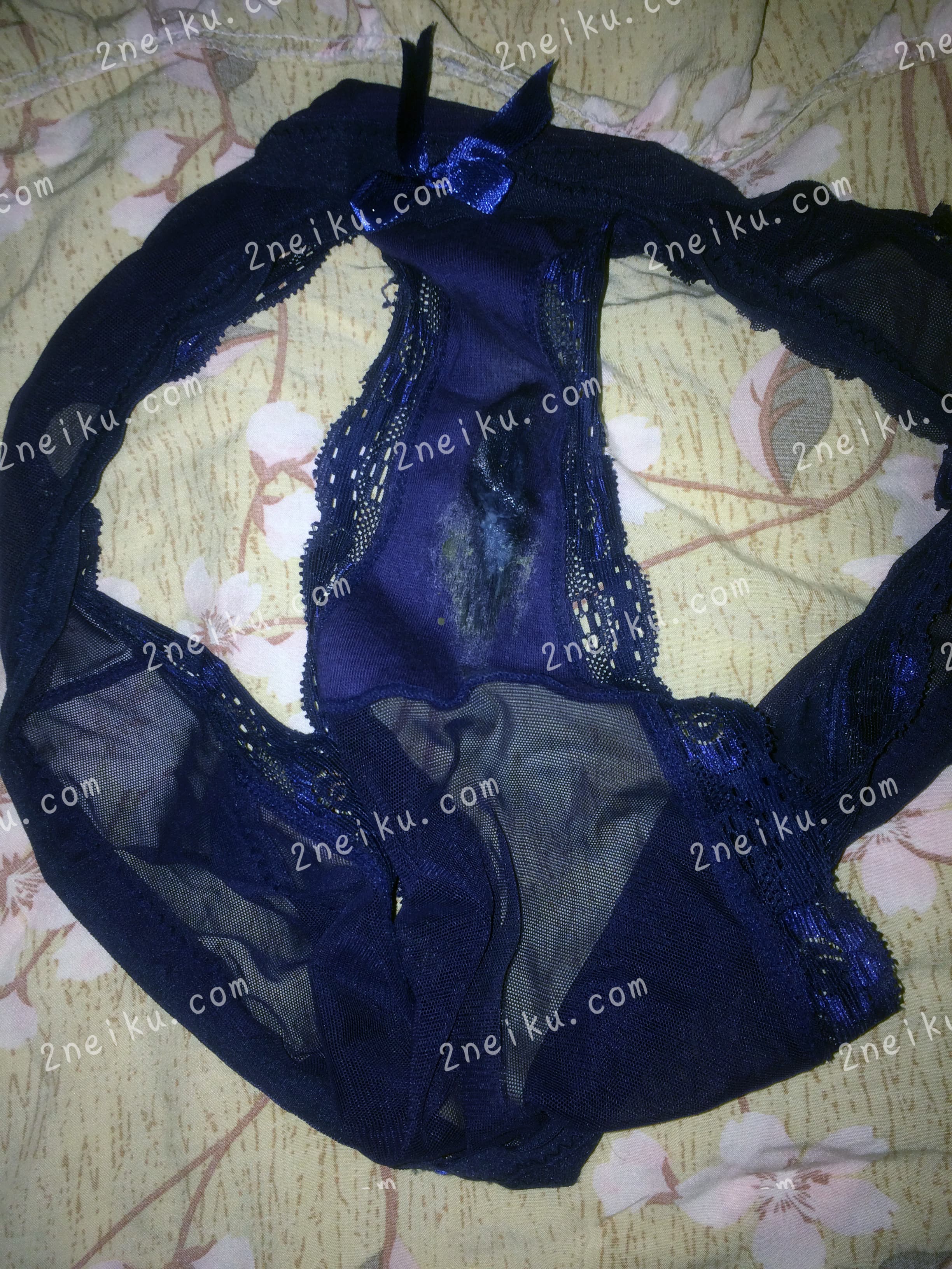 一条深蓝色脏的没有洗的蕾丝边女士内裤平铺照片