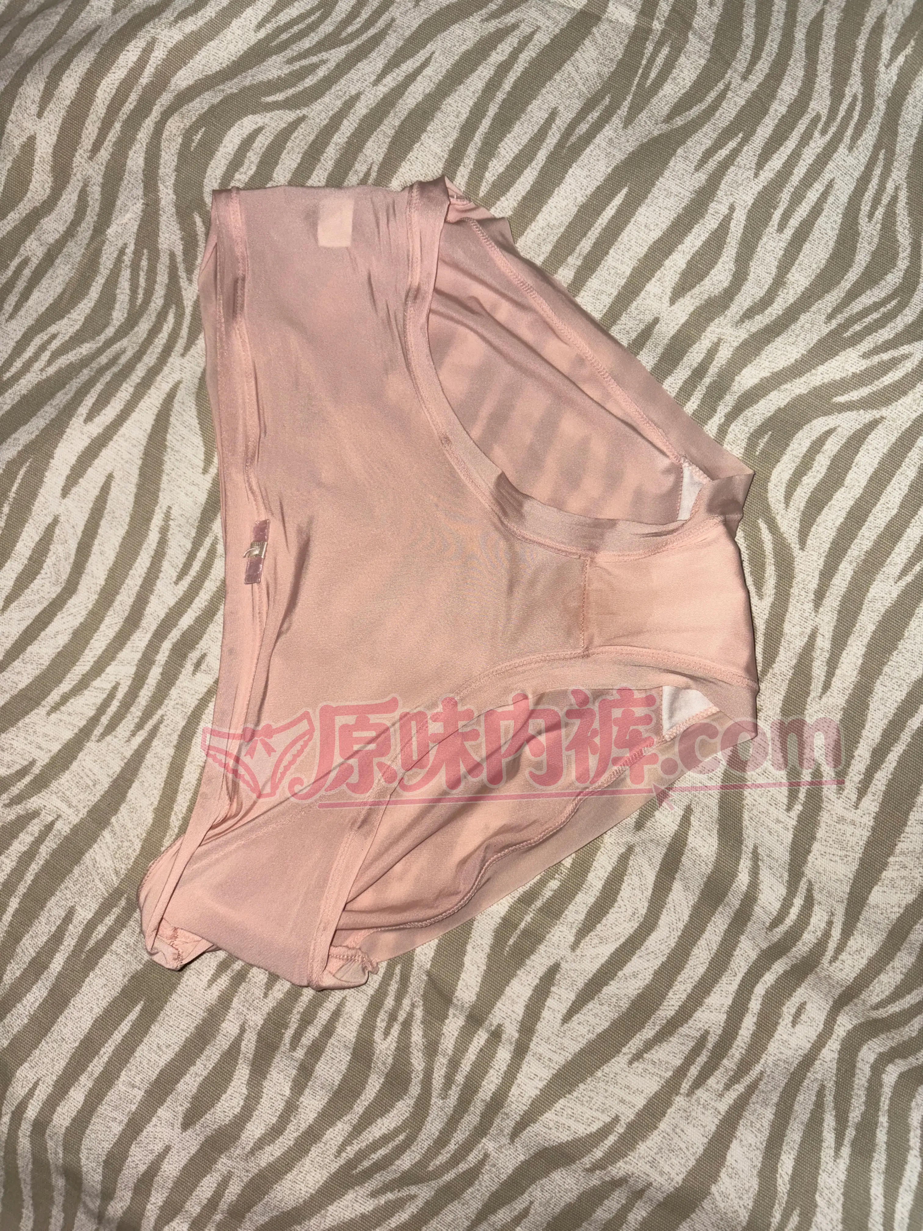 一条淡粉色冰丝原味内裤的平铺正面照片，裆部有明显分泌物脏脏的痕迹